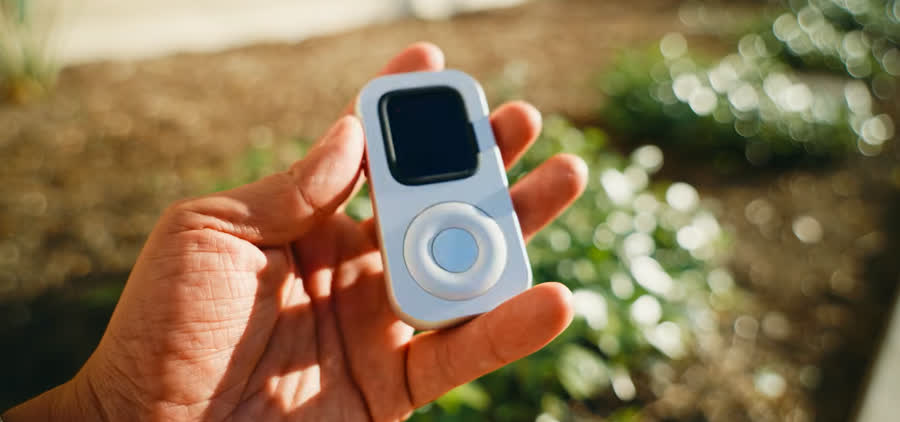 Front view of RePod C1 held outdoors with the screen dark before a listening session