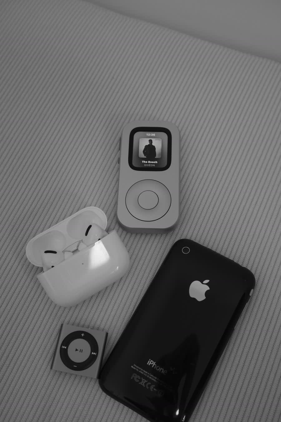 RePod C1 displayed with AirPods, an early iPhone, and a compact music player