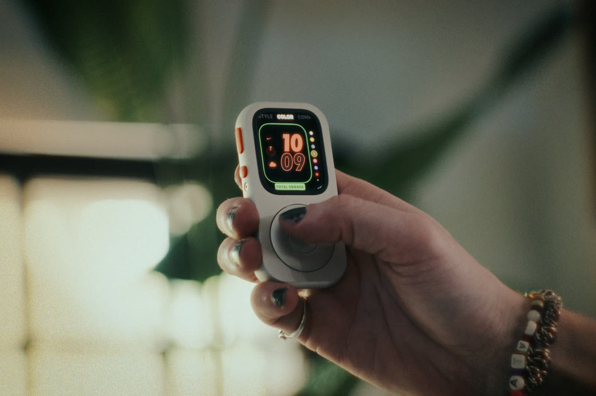 A front-facing RePod held in one hand with a clock face visible on the Apple Watch screen