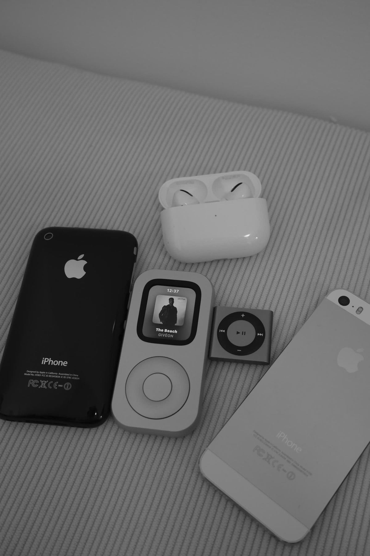 A front-facing RePod arranged with earlier Apple devices in a styled flat lay