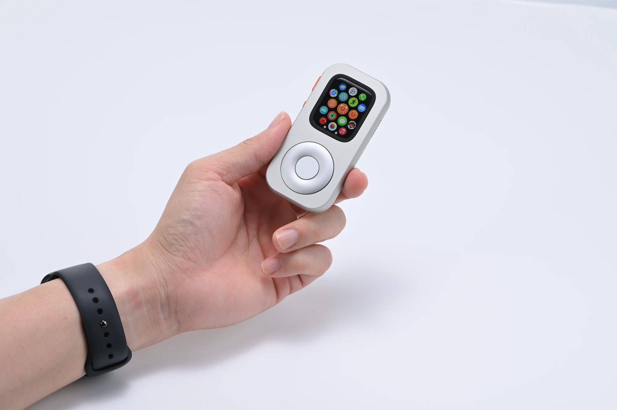 A hand holding the front of RePod C1 with its aluminum body and circular control visible
