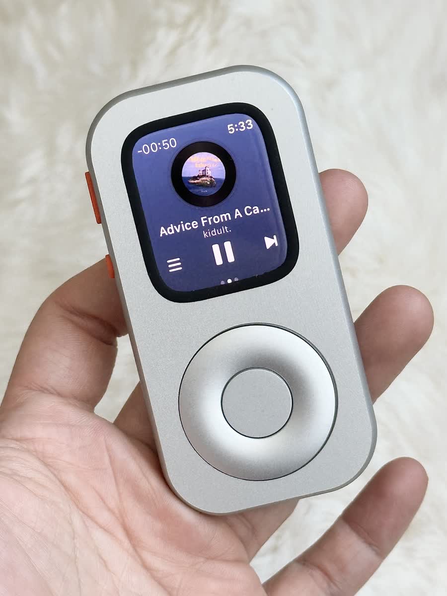 Hand holding a front-facing RePod C1 with music playing on Apple Watch