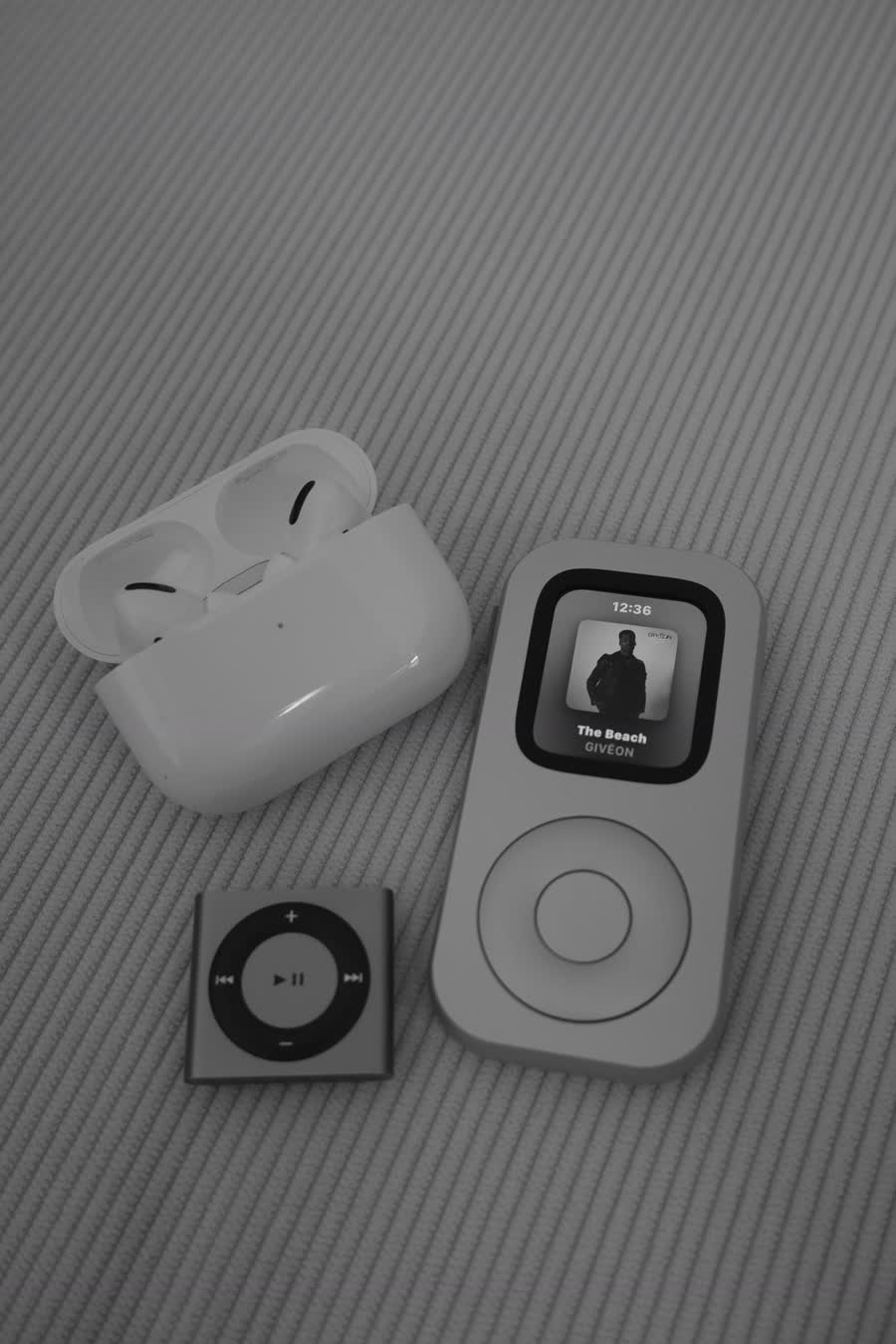 RePod C1 shown from the front with AirPods and a compact music player