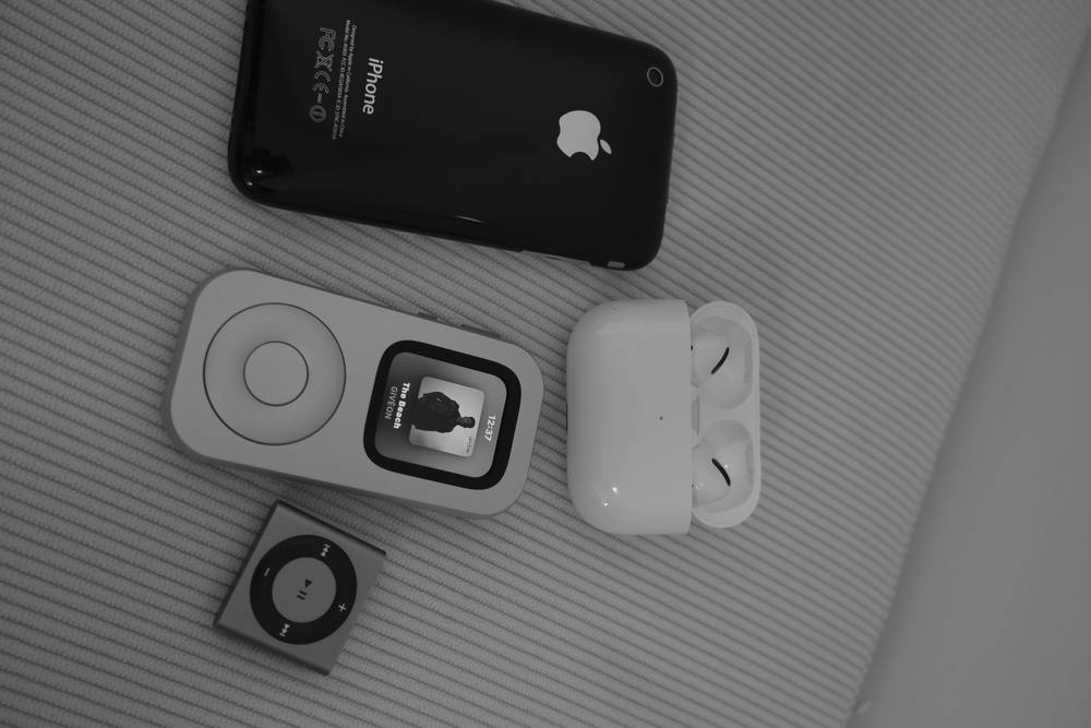 RePod, an iPhone, AirPods and a compact music player arranged in a black-and-white flat lay